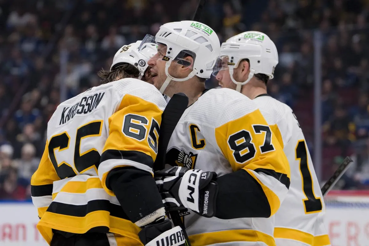 Pittsburgh Penguins defenseman Erik Karlsson (65) and forward Sidney Crosby (87) celebrate a goal scored by forward Rickard Rakell (67) against the Vancouver Canucksn the second period at Rogers Arena.