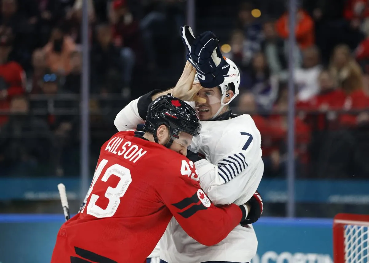 Tom Wilson of Canada clashes with Pierre Crinon of France in men's ice hockey group A play during the Milano Cortina 2026 Olympic Winter Games at Milano Santagiulia Ice Hockey Arena.