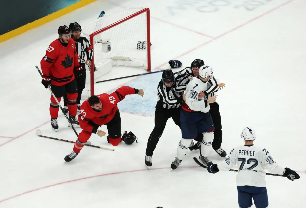 Tom Wilson of Canada clashes with Pierre Crinon of France in men's ice hockey group A play during the Milano Cortina 2026 Olympic Winter Games at Milano Santagiulia Ice Hockey Arena.