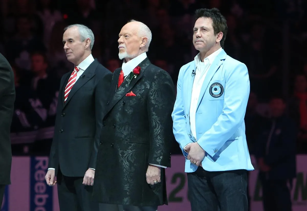 Former player Doug Gilmour (93) and Don Cherry (middle) and Ron MacLean (on left) stand for the playing of the anthems after ceremony marking the 60th anniversary of Hockey Night In Canada before the Toronto Maple Leafs game against the Boston Bruins at the Air Canada Centre. The Bruins beat the Maple Leafs 1-0.