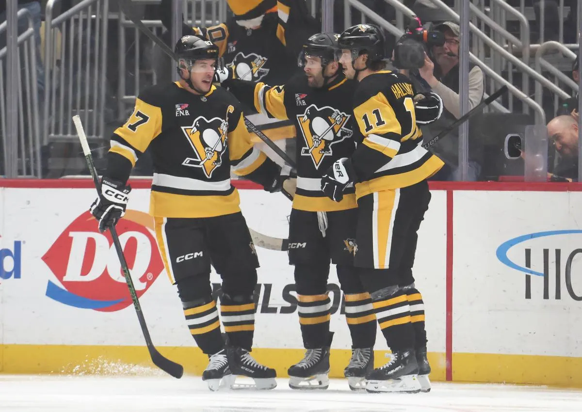 Pittsburgh Penguins center Sidney Crosby (87) and center Filip Hallander (11) congratulate right wing Bryan Rust (middle) on his goal against the St. Louis Blues during the first period at PPG Paints Arena.
