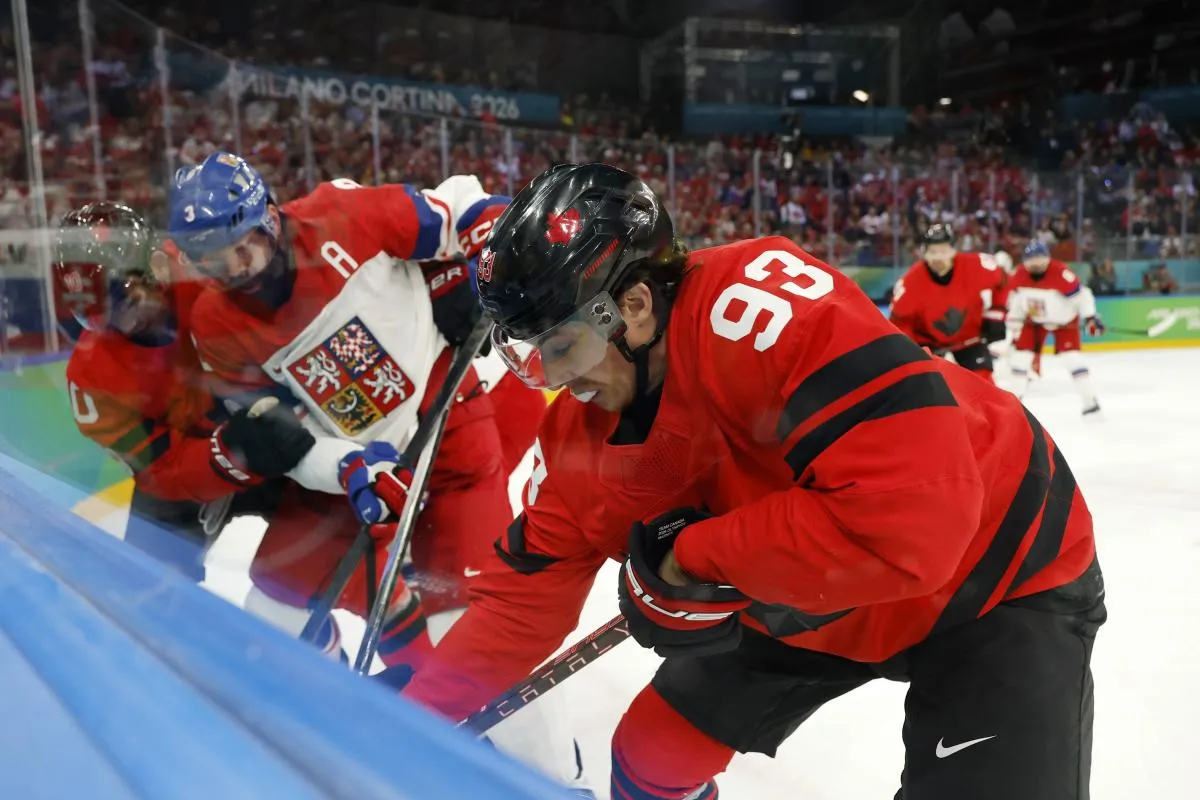 Mitch Marner of Canada battles for the puck against Radko Gudas of Czechia in a men's ice hockey quarterfinal during the Milano Cortina 2026 Olympic Winter Games at Milano Santagiulia Ice Hockey Arena.