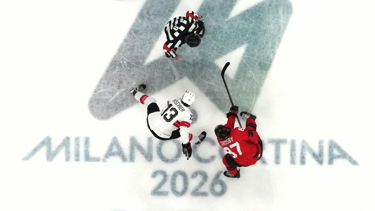Sidney Crosby of Canada in action with Nico Hischier of Switzerland during a face off in men's ice hockey group A play during the Milano Cortina 2026 Olympic Winter Games at Milano Santagiulia Ice Hockey Arena.