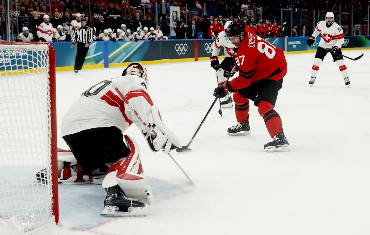 Sidney Crosby of Canada in action with Akira Schmid of Switzerland in men's ice hockey group A play during the Milano Cortina 2026 Olympic Winter Games at Milano Santagiulia Ice Hockey Arena