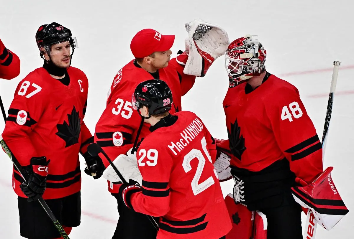 Nathan MacKinnon, Sidney Crosby, Darcy Kuemper and Logan Thompson of Canada celebrate after the match against Switzerland in men's ice hockey group A play during the Milano Cortina 2026 Olympic Winter Games at Milano Santagiulia Ice Hockey Arena.