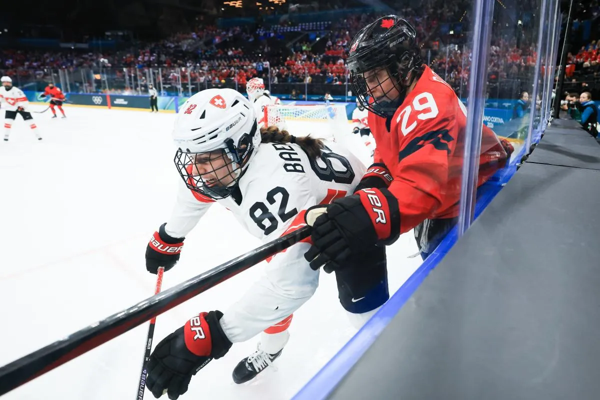 Marie-Philip Poulin (29) du Canada et Alessia Baechler (82) de Suisse se disputent le palet contre la bande lors de la troisi&egrave;me p&eacute;riode d'une demi-finale de hockey sur glace f&eacute;minin pendant les Jeux olympiques d'hiver de Milan-Cortina 2026 &agrave; la patinoire Milano Santagiulia Ice Hockey Arena.