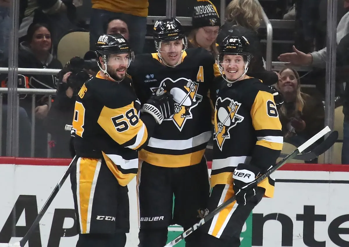 Pittsburgh Penguins center Evgeni Malkin (lmiddle) celebrates his game winning goal in overtime with defenseman Kris Letang (58) and right wing Rickard Rakell (67) against the Philadelphia Flyers at PPG Paints Arena.