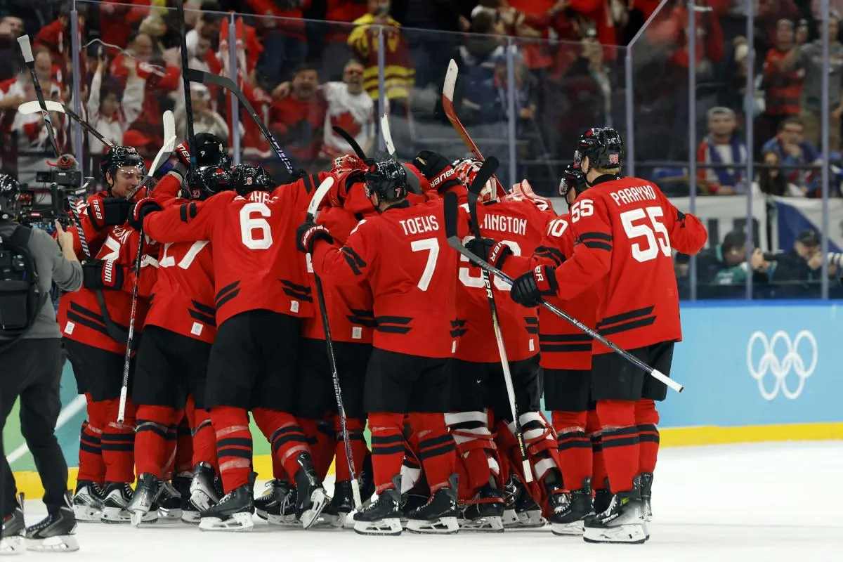 Nathan MacKinnon, Sidney Crosby, Darcy Kuemper and Logan Thompson of Canada celebrate after the match against Switzerland in men's ice hockey group A play during the Milano Cortina 2026 Olympic Winter Games at Milano Santagiulia Ice Hockey Arena.