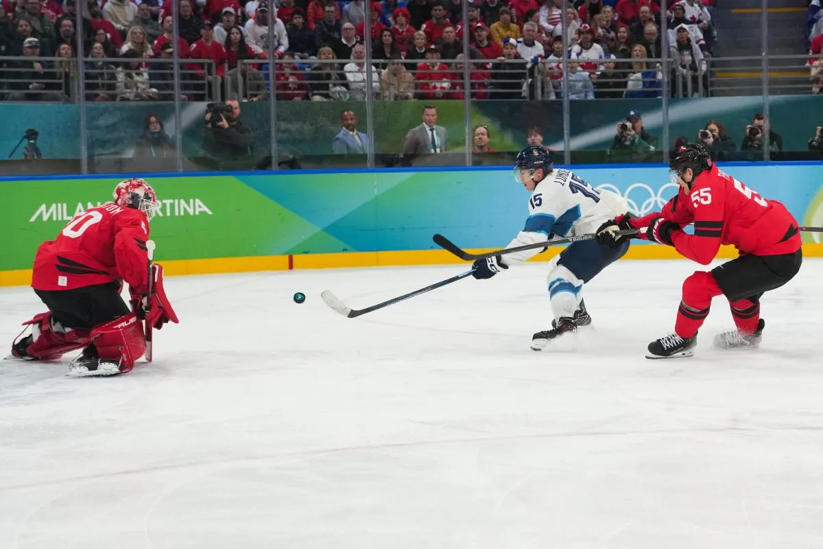 Anton Lundell (15) of Finland takes a shot on Jordan Binnington (50) of Canada during the third period in a men's ice hockey semifinal during the Milano Cortina 2026 Olympic Winter Games at Milano Santagiulia Ice Hockey Arena.