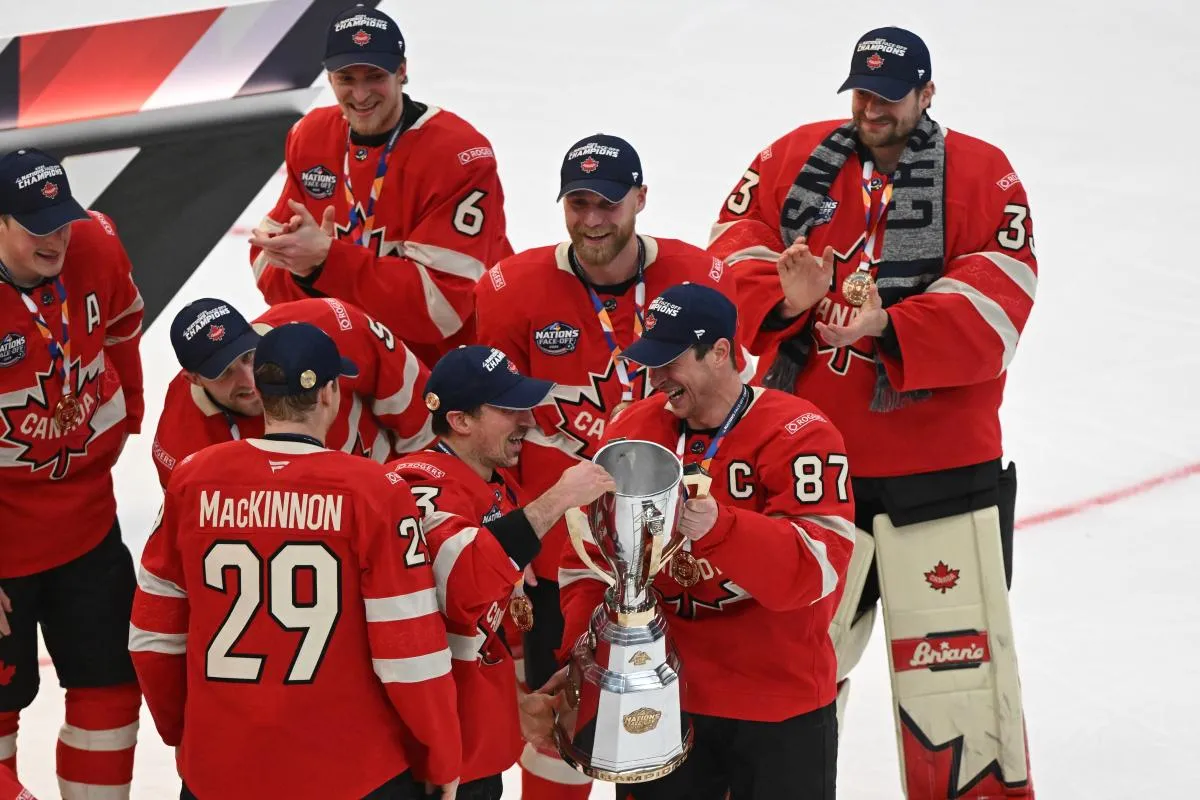 L'attaquant de l'&eacute;quipe canadienne Sidney Crosby (87) remet le troph&eacute;e du 4 Nations Face-Off &agrave; l'attaquant Brad Marchand (63) apr&egrave;s la victoire contre l'&eacute;quipe am&eacute;ricaine en prolongation lors du match de championnat de hockey sur glace du 4 Nations Face-Off au TD Garden.