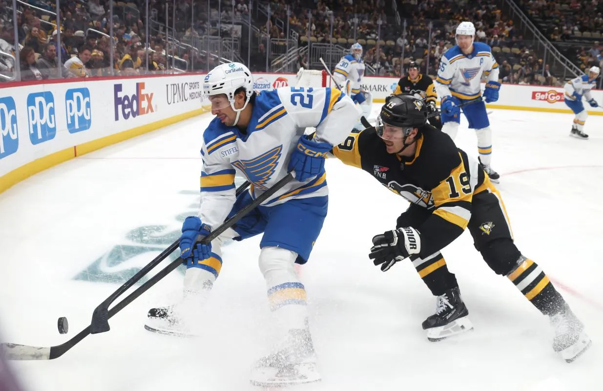 St. Louis Blues right wing Jordan Kyrou (25) handles the puck against pressure from Pittsburgh Penguins center Connor Dewar (19) during the third period at PPG Paints Arena.