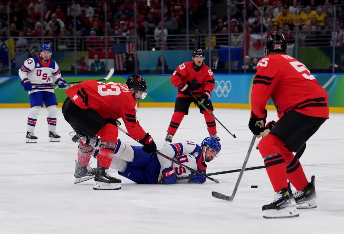 Dylan Larkin (21) of the United States battles for the puck against Tom Wilson (43) of Canada in the men's ice hockey gold medal game during the Milano Cortina 2026 Olympic Winter Games at Milano Santagiulia Ice Hockey Arena.