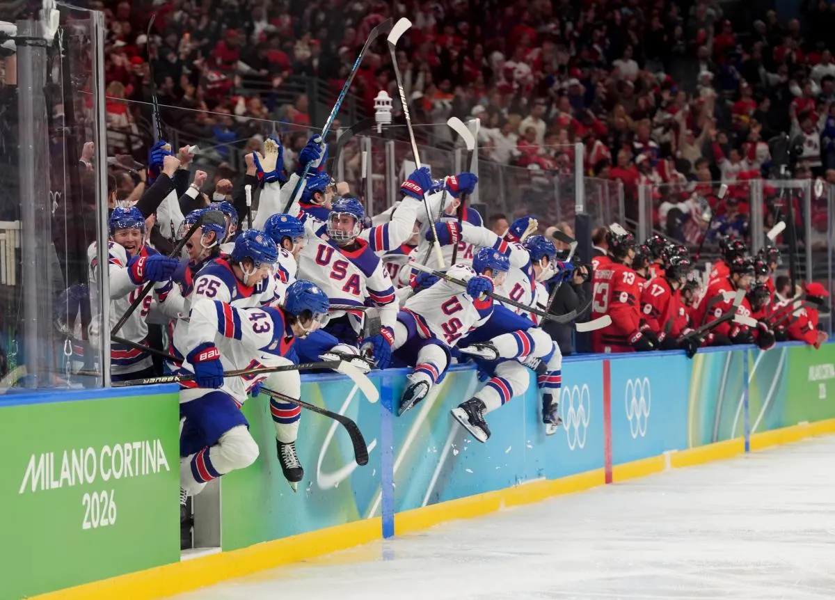 United States bench react after the game-winning goal is scored by Jack Hughes (not pictured) of the United States against Canada in the men's ice hockey gold medal game during the Milano Cortina 2026 Olympic Winter Games at Milano Santagiulia Ice Hockey Arena.