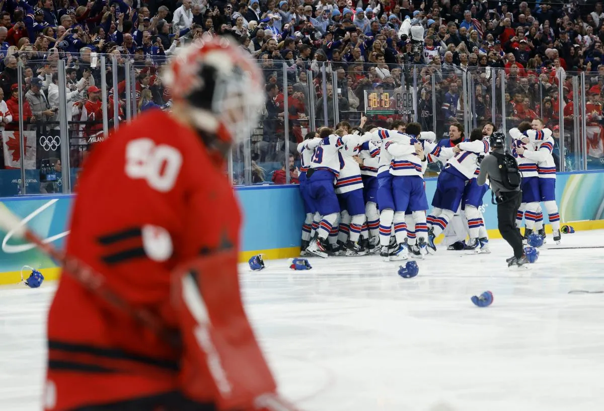 Les joueurs am&eacute;ricains c&eacute;l&egrave;brent la victoire tandis que Jordan Binnington (50) du Canada quitte la glace apr&egrave;s la finale masculine de hockey sur glace des Jeux olympiques d'hiver de Milan-Cortina 2026 &agrave; la patinoire Milano Santagiulia Ice Hockey Arena.