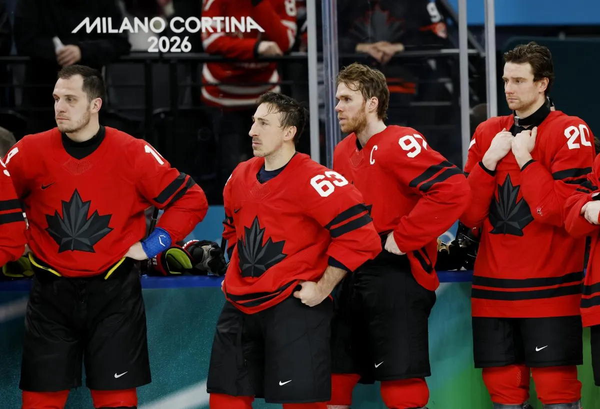 Brad Marchand (63) of Canada and Connor McDavid (97) of Canada react after losing to the United States in the men's ice hockey gold medal game during the Milano Cortina 2026 Olympic Winter Games at Milano Santagiulia Ice Hockey Arena.