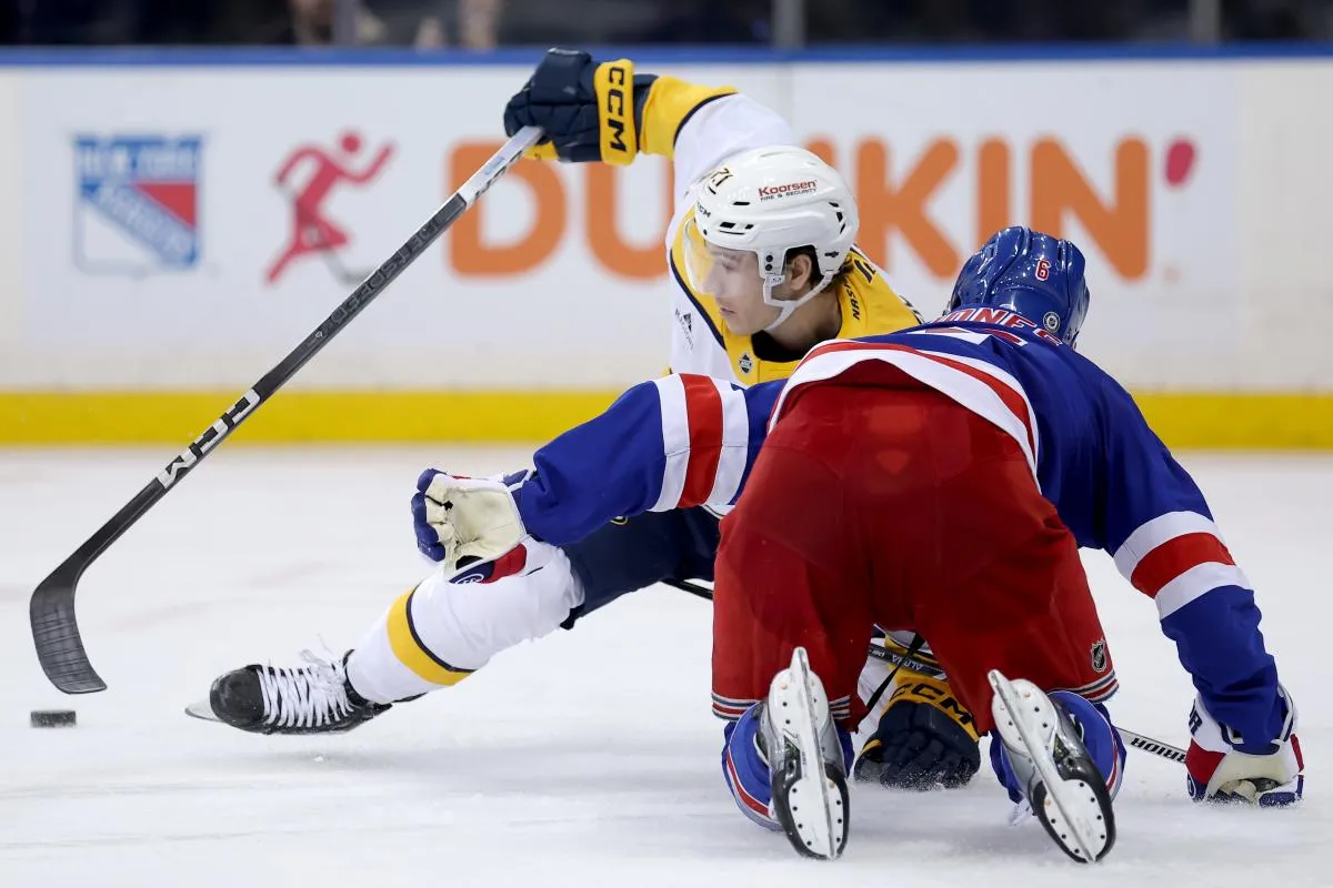 Nashville Predators center Jake Lucchini (21) and New York Rangers defenseman Zac Jones (6) fight for the puck during the third period at Madison Square Garden.