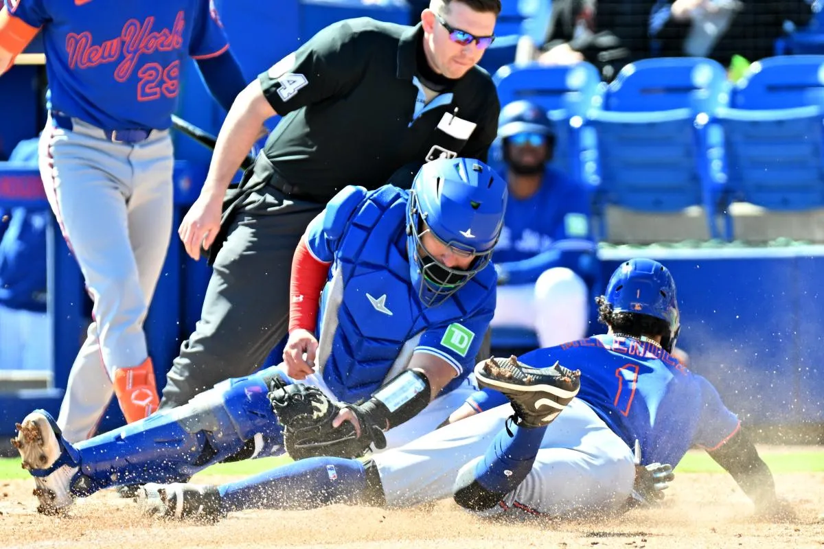 Toronto Blue Jays catcher Alejandro Kirk (30) tags out New York Mets right fielder MJ Melendez (1) on a steal attempt in the third inning during spring training at TD Ballpark.