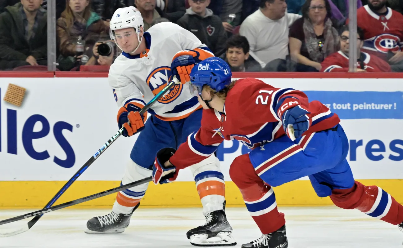 L'attaquant des Islanders de New York Julien Gauthier (16) joue le palet et le d&eacute;fenseur des Canadiens de Montr&eacute;al Kaiden Guhle (21) d&eacute;fend pendant la premi&egrave;re p&eacute;riode au Centre Bell.