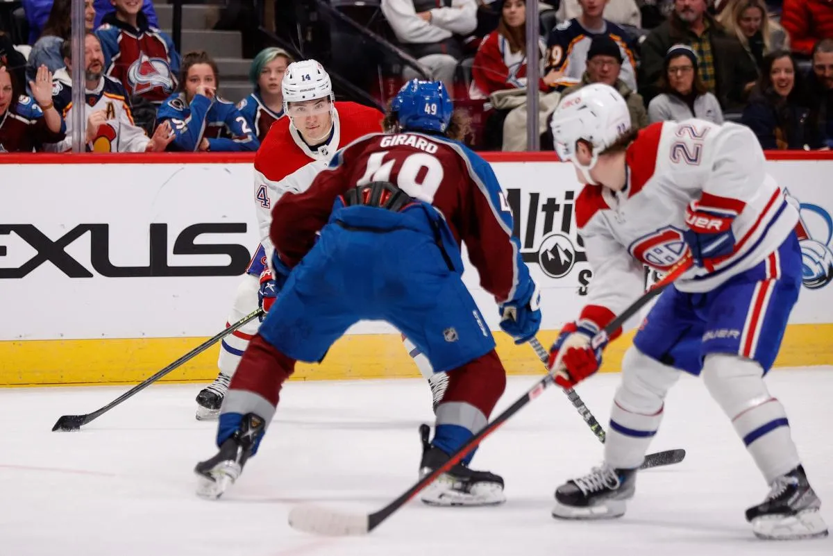 Montreal Canadiens center Nick Suzuki (14) looks to pass the puck to right wing Cole Caufield (22) as Colorado Avalanche defenseman Samuel Girard (49) defends in the third period at Ball Arena.