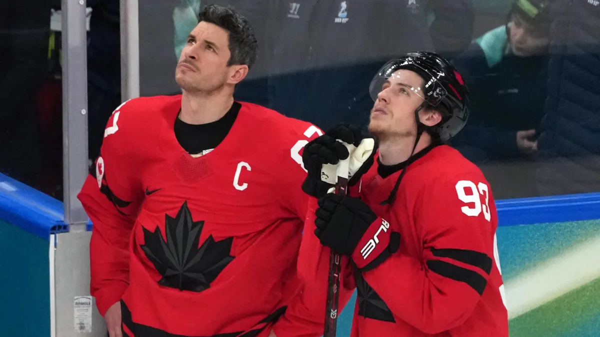 Sidney Crosby (87) and Mitch Marner (93) of Canada look on after losing to the United States in the men's ice hockey gold medal game during the Milano Cortina 2026 Olympic Winter Games at Milano Santagiulia Ice Hockey Arena.