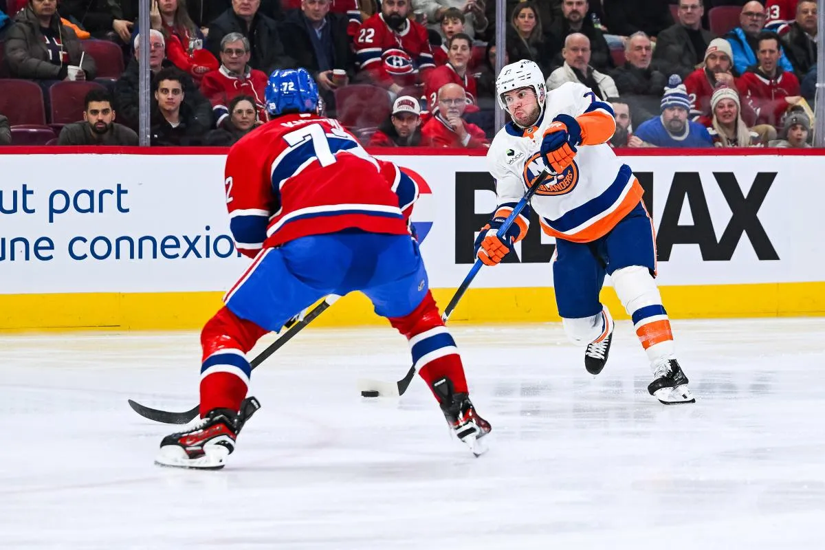 Le d&eacute;fenseur des Islanders de New York Tony DeAngelo (77) tire la rondelle contre le d&eacute;fenseur des Canadiens de Montr&eacute;al Arber Xhekaj (72) pendant la troisi&egrave;me p&eacute;riode au Centre Bell.