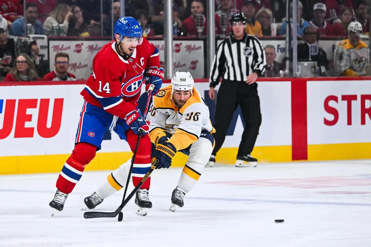 Le centre des Canadiens de Montr&eacute;al Nick Suzuki (14) joue la rondelle contre le centre des Predators de Nashville Ryan O'Reilly (90) pendant la deuxi&egrave;me p&eacute;riode au Centre Bell.