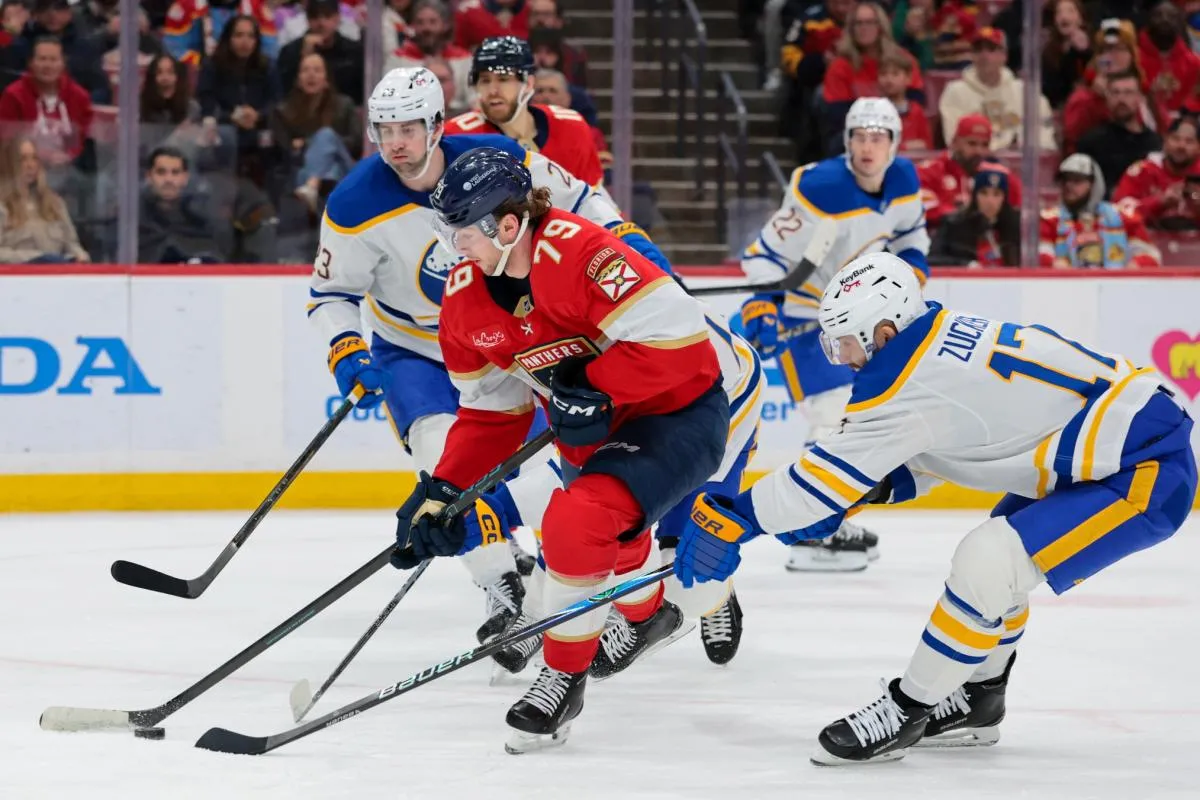 Florida Panthers center Cole Schwindt (79) moves the puck against Buffalo Sabres left wing Jason Zucker (17) and defenseman Mattias Samuelsson (23) during the first period at Amerant Bank Arena.