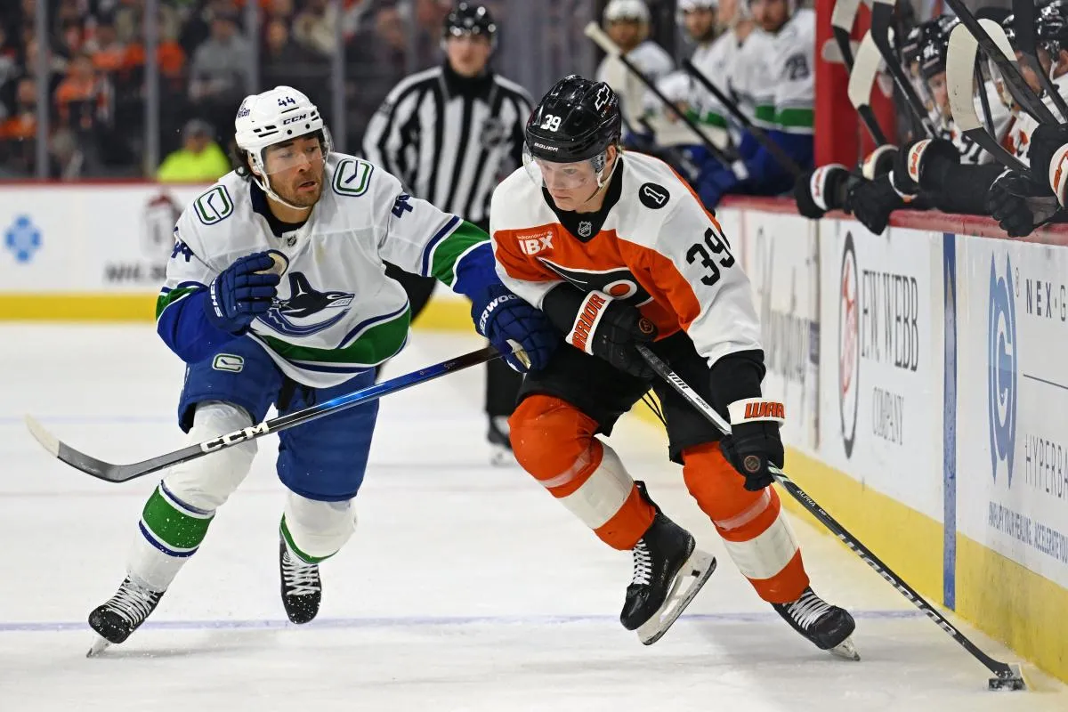 Philadelphia Flyers right wing Matvei Michkov (39) skates with the puck against Vancouver Canucks left wing Kiefer Sherwood (44) at Xfinity Mobile Arena.