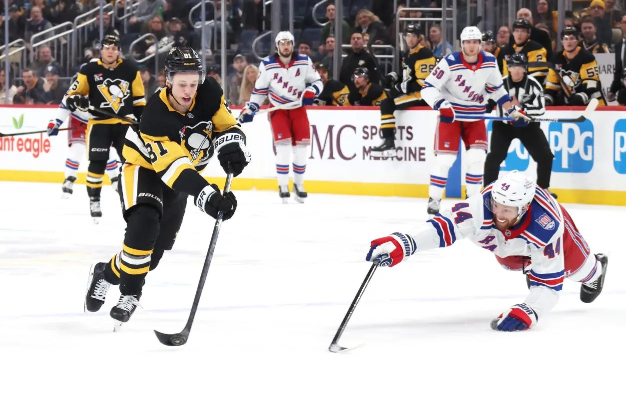 Pittsburgh Penguins center Ben Kindel (81) shoots to score an empty net goal past New York Rangers defenseman Vladislav Gavrikov (44) during the third period at PPG Paints Arena.