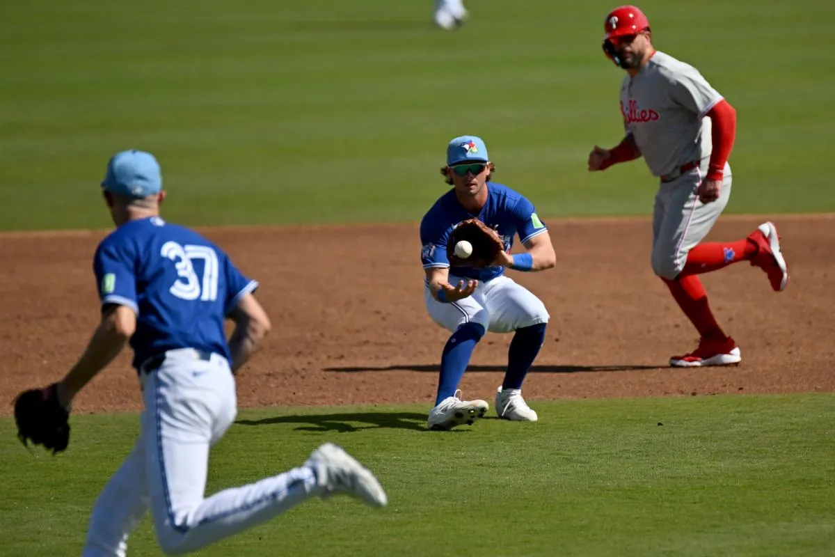 Toronto Blue Jays third baseman Ben Cowles (20) fields a ground ball in the third inning against the Philadelphia Phillies during spring training at TD Ballpark.