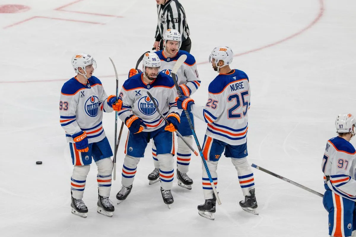 Edmonton Oilers defenseman Jake Walman (96) celebrates after scoring a goal with Edmonton Oilers center Ryan Nugent-Hopkins (93) and teammates against the San Jose Sharks during the third period at SAP Center at San Jose.