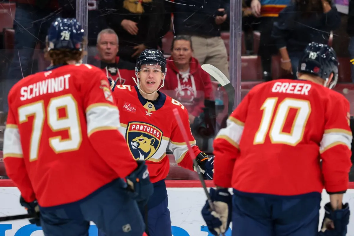 Florida Panthers left wing Sandis Vilmanis (95) celebrates with center Cole Schwindt (79) and left wing A.J. Greer (10) after scoring against the Buffalo Sabres during the first period at Amerant Bank Arena.