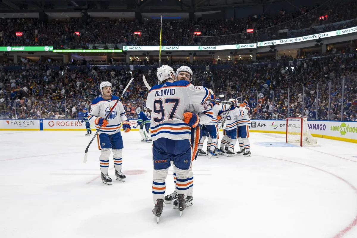 Edmonton Oilers forward Mattias Janmark (13) and forward Leon Draisaitl (29) and forward Connor McDavid (97) celebrate their victory against the Vancouver Canucks during the first overtime in game two of the second round of the 2024 Stanley Cup Playoffs at Rogers Arena.