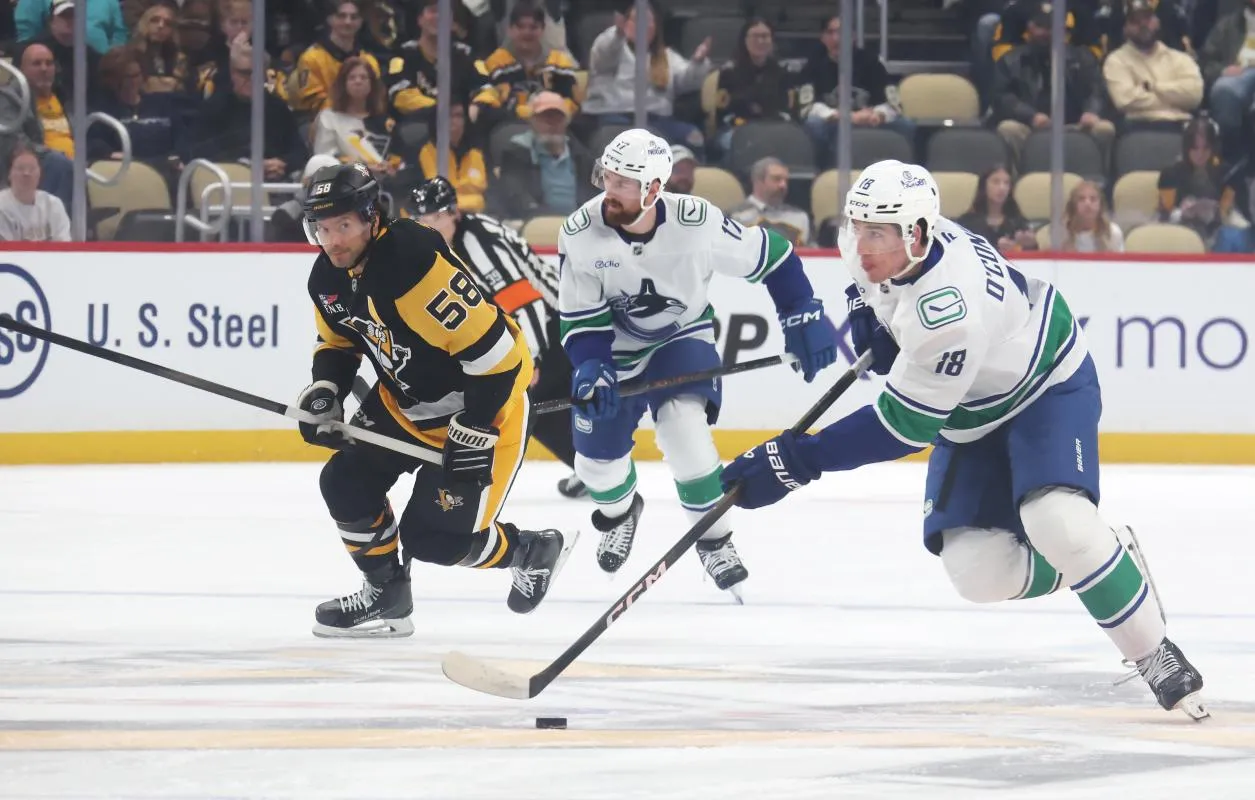 Vancouver Canucks left wing Drew O'Connor (18) skates with the puck against the Pittsburgh Penguins during the first period at PPG Paints Arena.