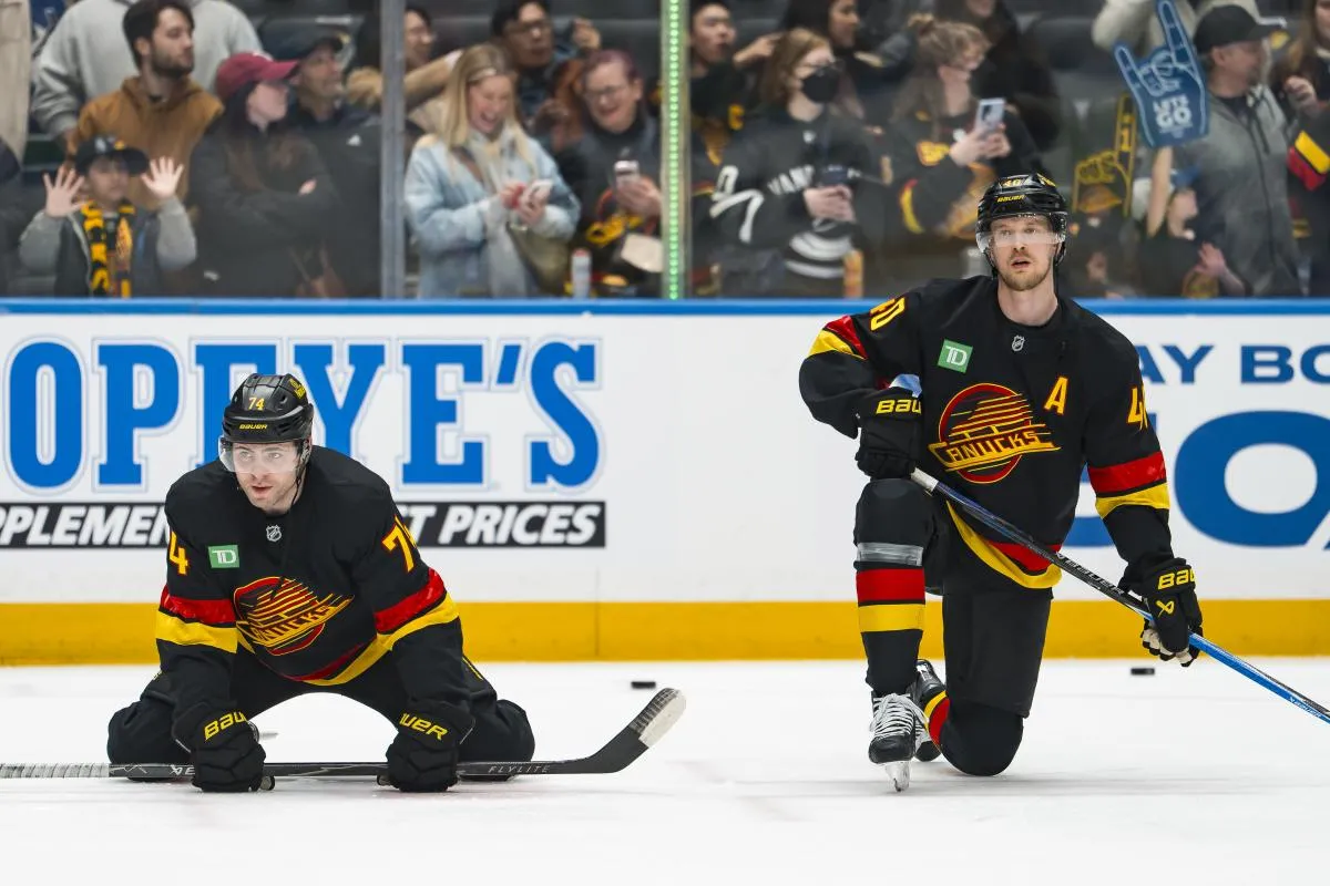 Vancouver Canucks forward Jake DeBrusk (74) and forward Elias Pettersson (40) stretch in warm up prior to a game against the Dallas Stars at Rogers Arena.