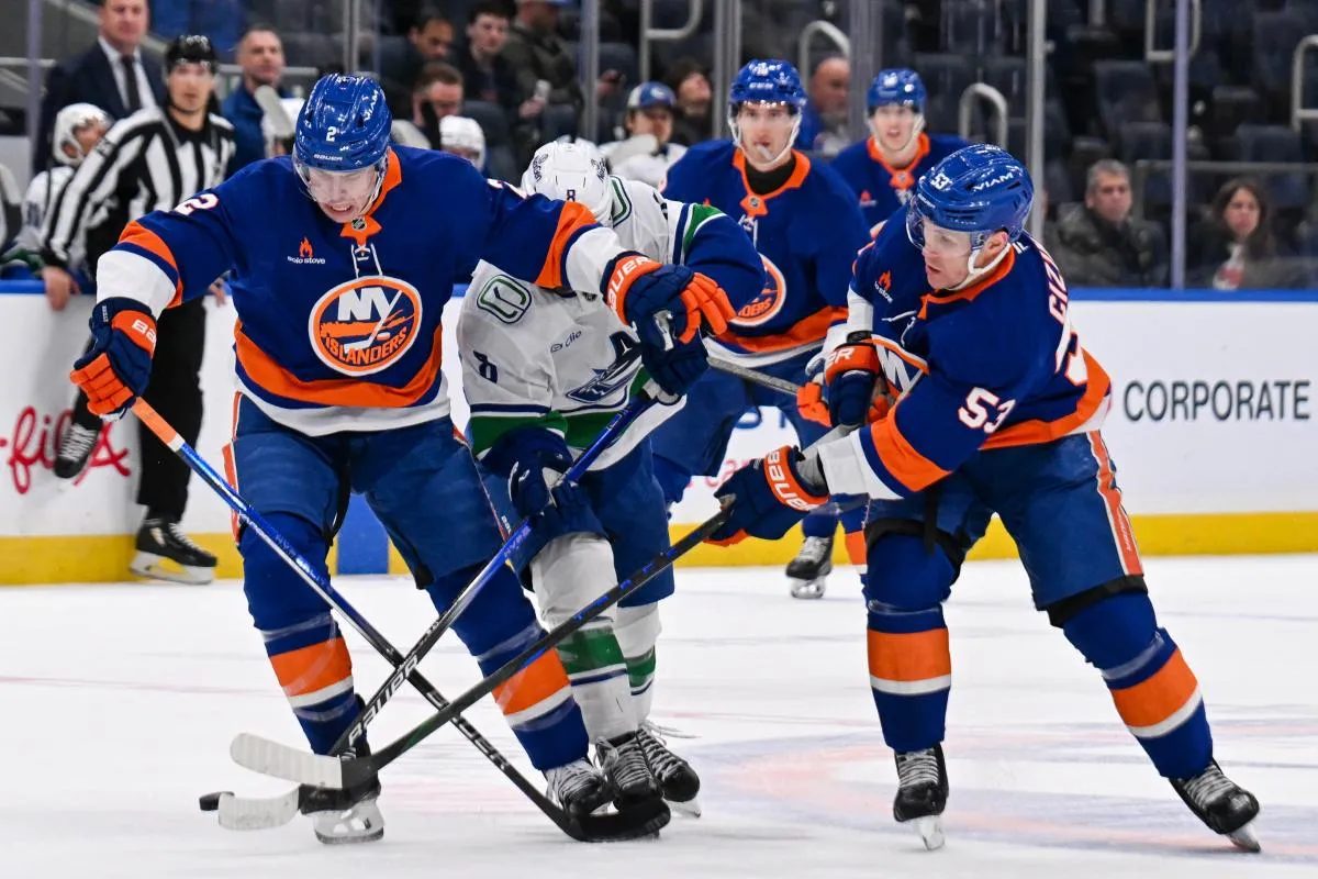 New York Islanders defenseman Mike Reilly (2) and center Casey Cizikas (53) battle with Vancouver Canucks right wing Conor Garland (8) during the first period at UBS Arena.