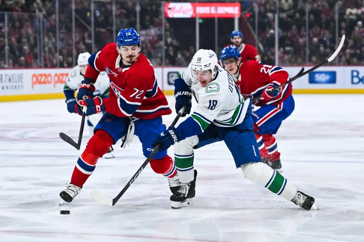 L'ailier gauche des Canucks de Vancouver, Drew O'Connor (18), tire la rondelle contre le d&eacute;fenseur des Canadiens de Montr&eacute;al, Arber Xhekaj (72), pendant la premi&egrave;re p&eacute;riode au Centre Bell.