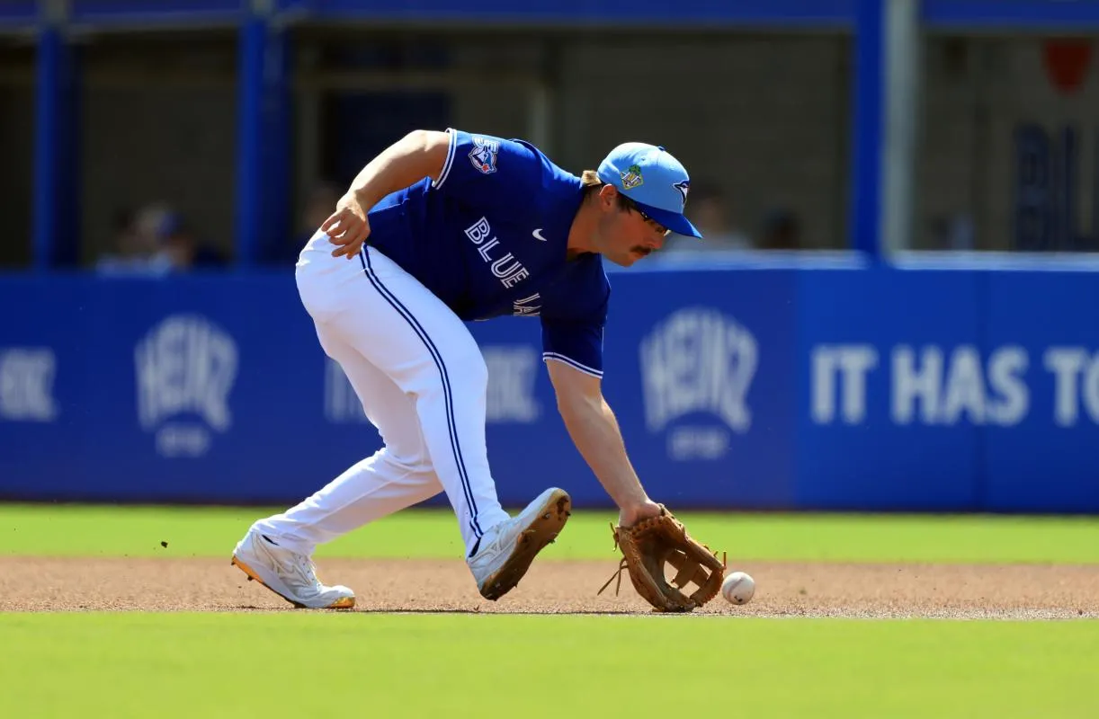Toronto Blue Jays infielder Davis Schneider (36) fields the ball and then throws the ball to first base for an out during the first inning against Team Canada at TD Ballpark.