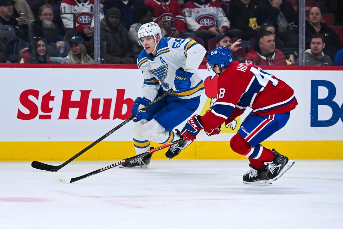 Le d&eacute;fenseur des Blues de Saint-Louis Colton Parayko (55) joue la rondelle contre le d&eacute;fenseur des Canadiens de Montr&eacute;al Lane Hutson (48) pendant la deuxi&egrave;me p&eacute;riode au Centre Bell.