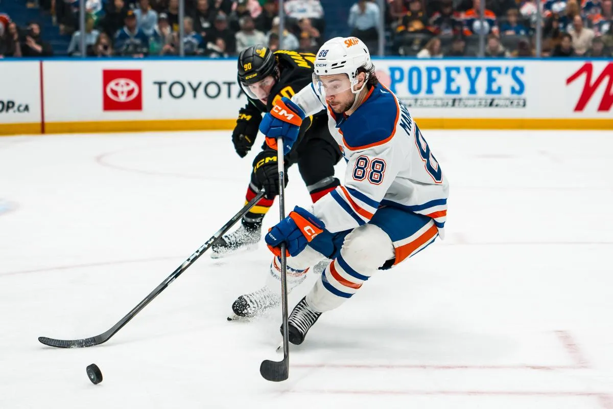 Vancouver Canucks defenseman Victor Mancini (90) stick checks Edmonton Oilers forward Andrew Mangiapane (88) in the third period at Rogers Arena.