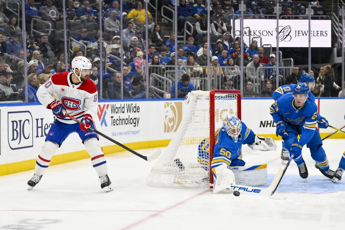 le gardien des Blues de Saint-Louis, Jordan Binnington (50), et le d&eacute;fenseur Logan Mailloux (23) d&eacute;fendent leur filet face au centre des Canadiens de Montr&eacute;al, Joe Veleno (90), durant la premi&egrave;re p&eacute;riode au Enterprise Center.