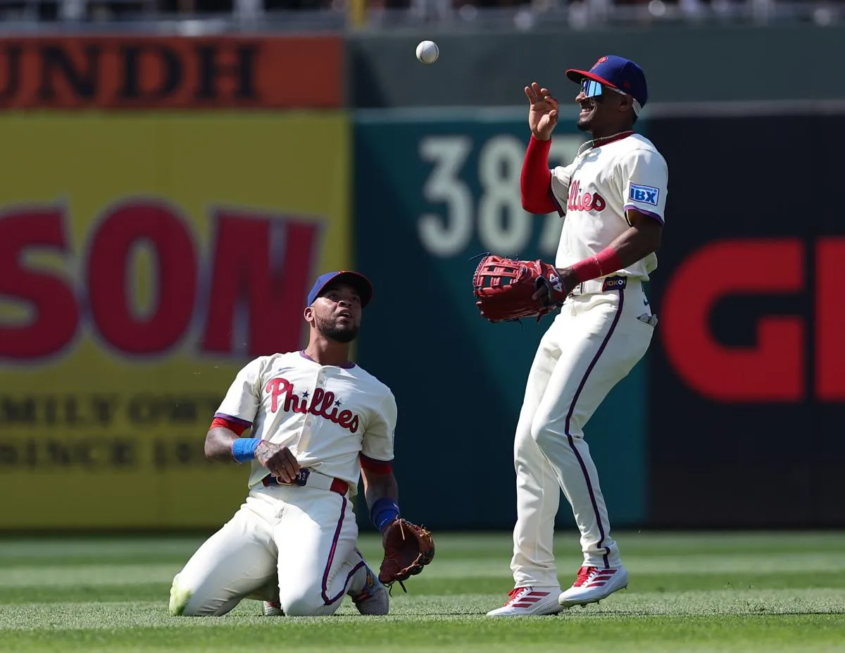 Philadelphia Phillies second base Edmundo Sosa (33) tosses the ball to outfielder Johan Rojas (23) after a leaping catch for an out against the Cincinnati Reds during the first inning at Citizens Bank Park.