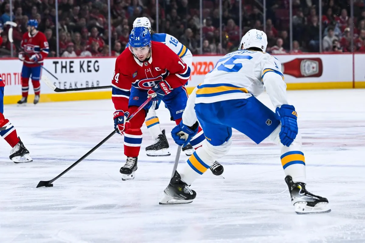 Le centre des Canadiens de Montr&eacute;al Nick Suzuki (14) joue la rondelle contre le d&eacute;fenseur des Blues de Saint-Louis Colton Parayko (55) pendant la troisi&egrave;me p&eacute;riode au Centre Bell.