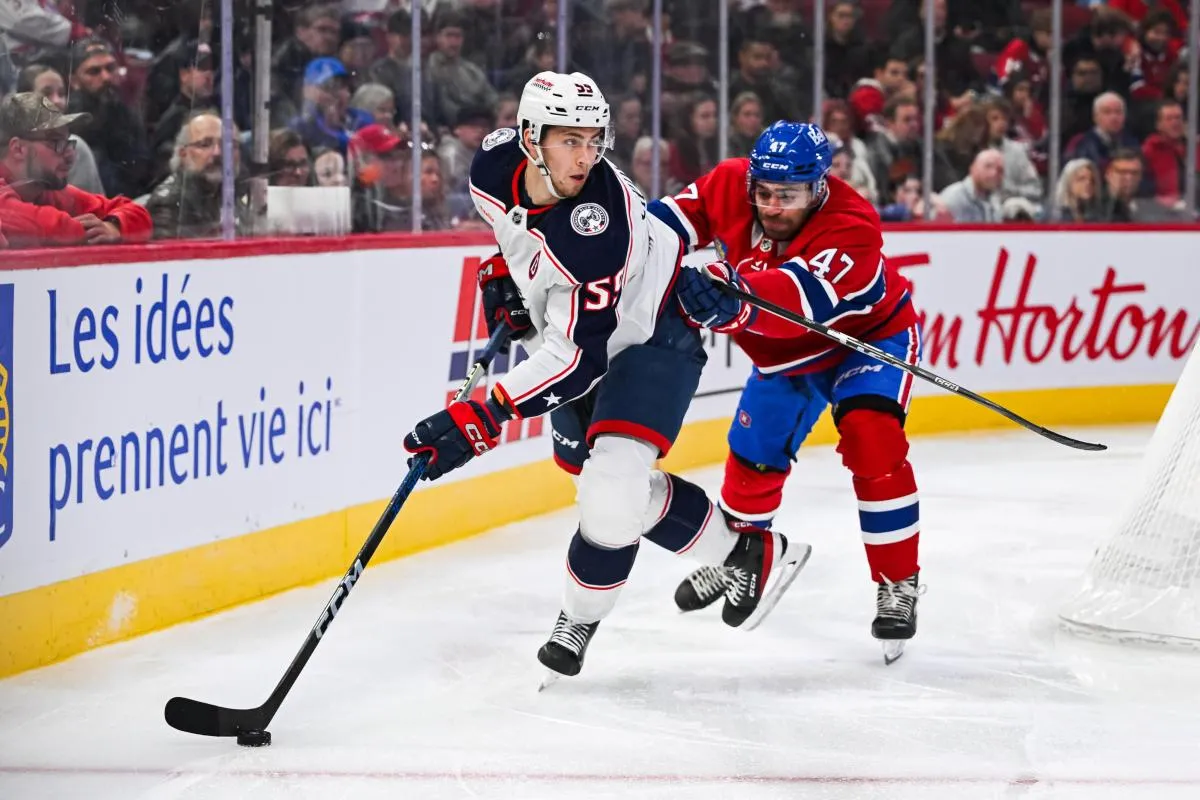 Le d&eacute;fenseur des Blue Jackets de Columbus, David Jiricek (55), joue la rondelle contre le d&eacute;fenseur des Canadiens de Montr&eacute;al, Jayden Struble (47), pendant la troisi&egrave;me p&eacute;riode au Centre Bell.