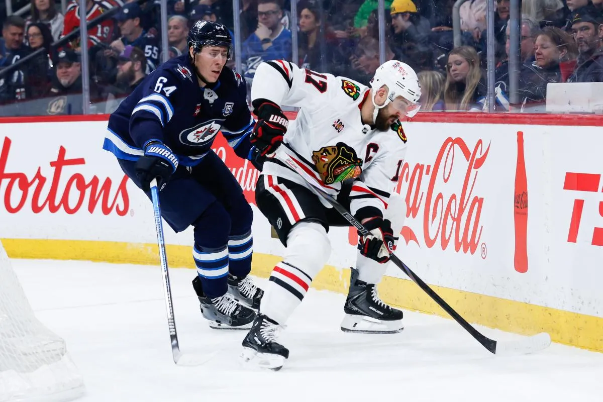 Chicago Blackhawks forward Nick Foligno (17) shields the puck from Winnipeg Jets defenseman Logan Stanley (64) during the first period at Canada Life Centre.