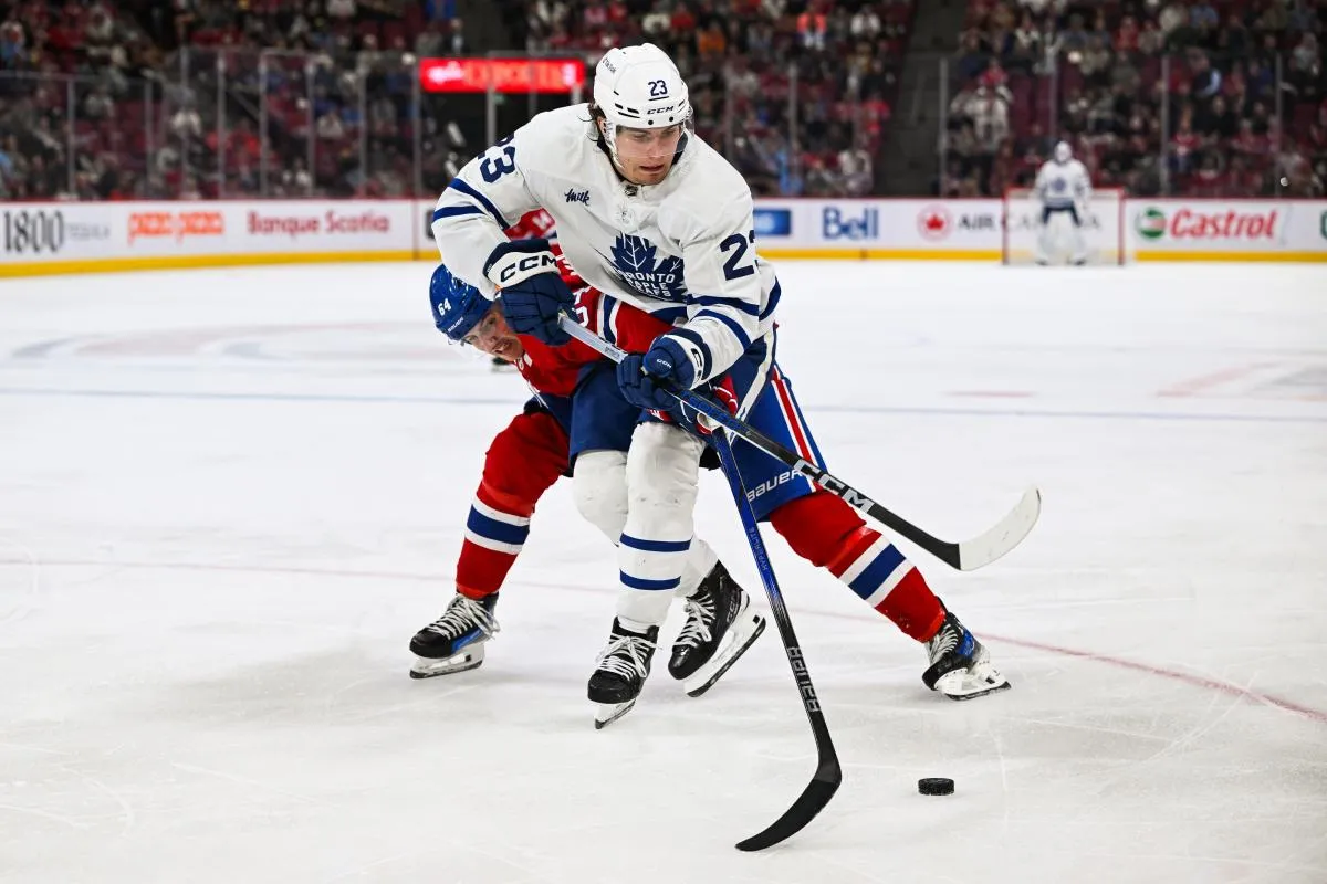 L'ailier gauche des Maple Leafs de Toronto, Matthew Knies (23), joue la rondelle contre le d&eacute;fenseur des Canadiens de Montr&eacute;al, David Reinbacher (64), au cours de la troisi&egrave;me p&eacute;riode au Centre Bell.