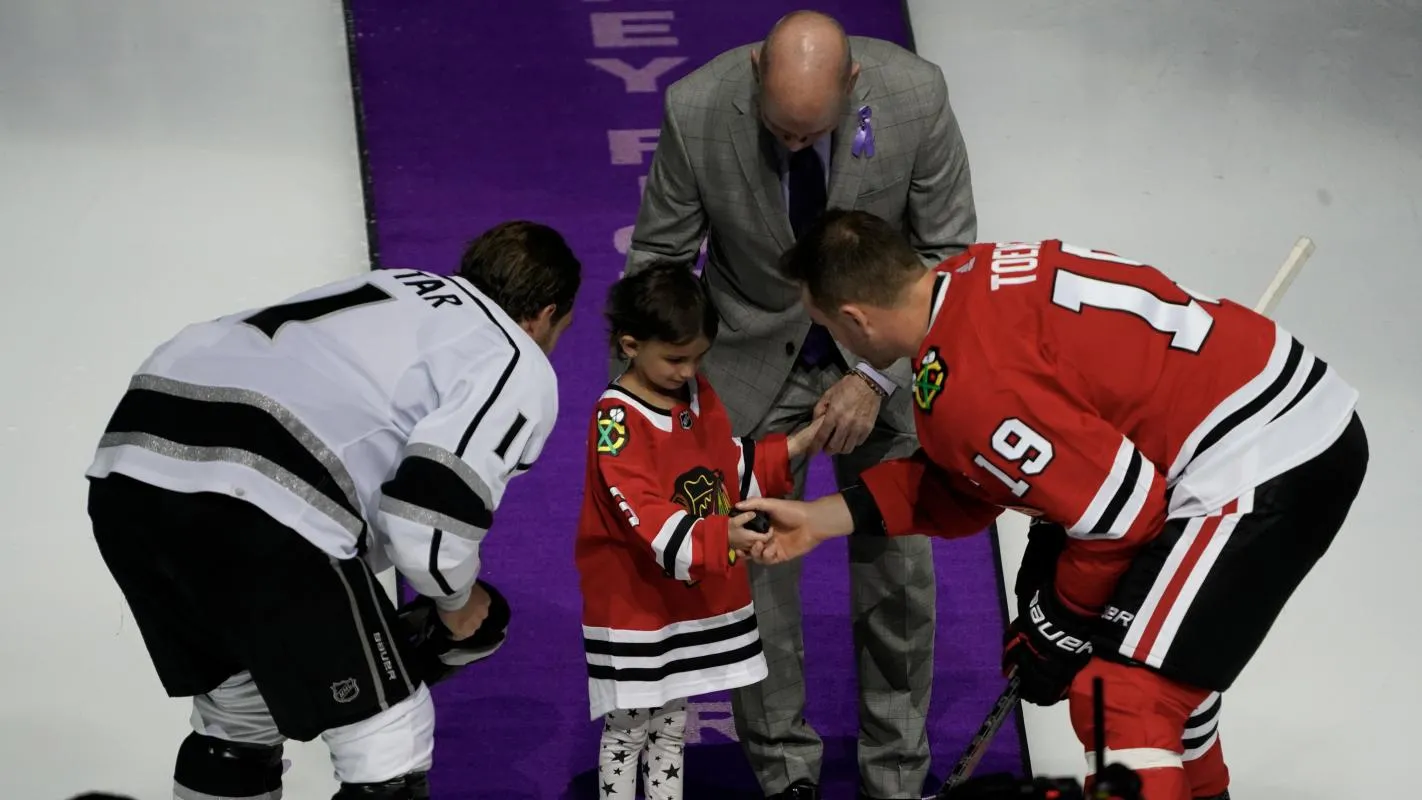 Los Angeles Kings center Anze Kopitar (11) Chicago Blackhawks center Jonathan Toews (19) Troy Murray and cancer survivor six year old Penelope Gomez is honored during Hockey Fights Cancer Night before the first period at United Center.