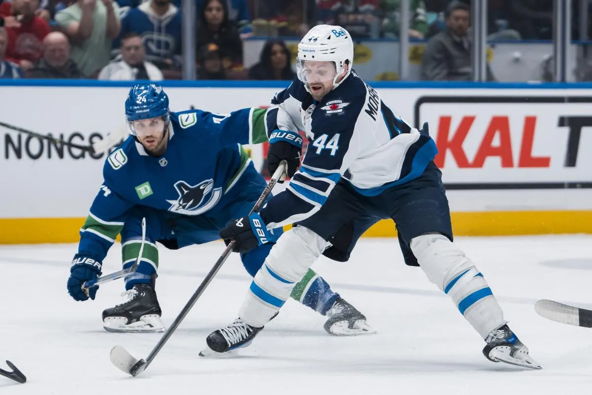 Vancouver Canucks forward Pius Suter (24) watches as Winnipeg Jets defenseman Josh Morrissey (44) handles the puck in the third period at Rogers Arena.