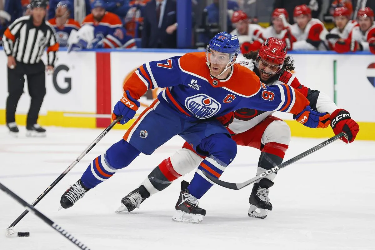Edmonton Oilers forward Connor McDavid (97) protects the puck from Carolina Hurricanes defensemen Jalen Chatfield (5) during the third period at Rogers Place.