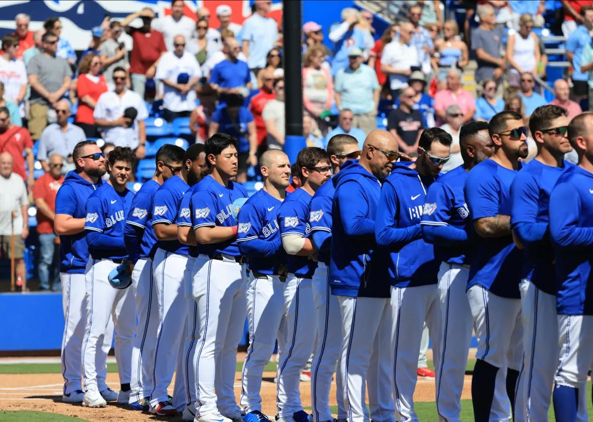 Toronto Blue Jays manager John Schneider (14) and teammates look on during the National Anthem against the Philadelphia Phillies at TD Ballpark.